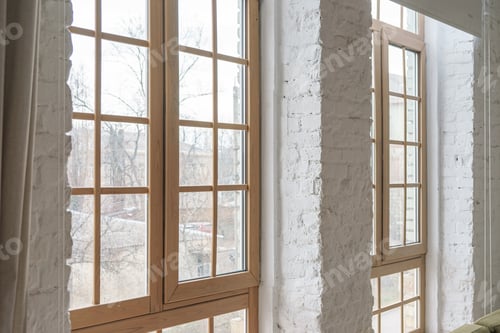 Preview: Large windows with wooden frames in loft interior with white brick walls inside apartment or house