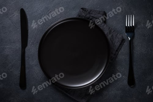 Preview: Black plate, cutlery and napkin on stone table top view
