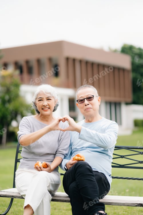 Preview: Asian senior couple having a good time. They laughing and smiling while sitting outdoor at the park.