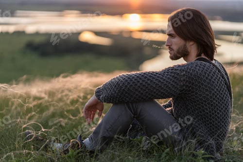 Preview: a young man looks at a beautiful sunset