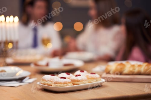 Preview: Hanukkah dinner. Family gathered around the table with traditional dishes