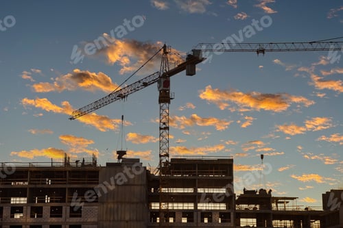 Preview: Construction Site Under a Colorful Sky at Sunset With a Crane and Workers in Action