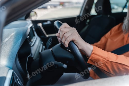 Preview: Close-up female driver hands on the steering wheel while driving car.