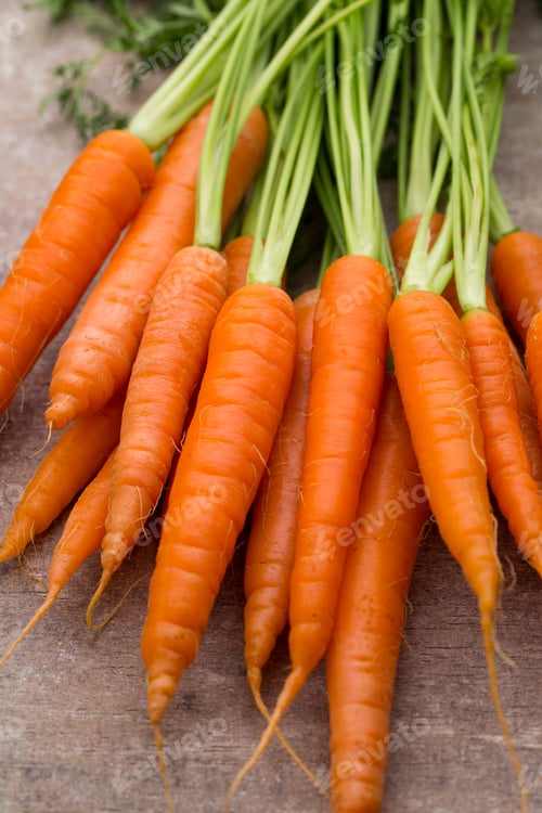 Preview: Fresh and sweet carrot on a grey wooden table.