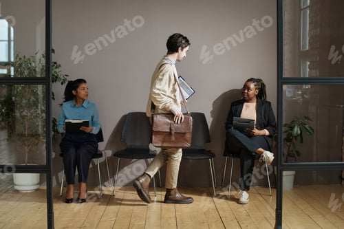 Preview: People sitting at office corridor