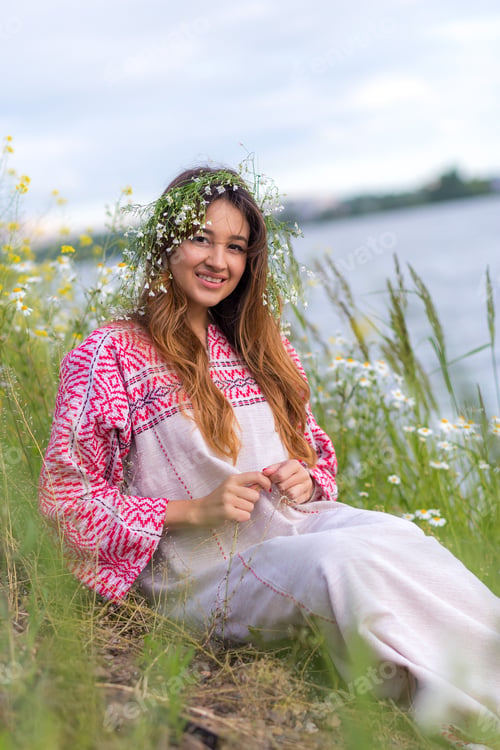 Preview: fashionable girl sits on the shore of the lake, river