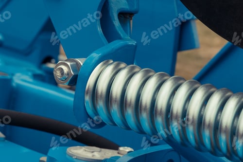 Preview: Silver hard spring made of steel. Part of big blue industrial or agricultural machine