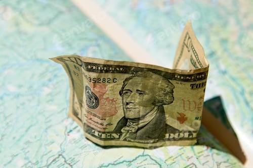 Preview: High angle shot of a US 10 dollar cash on a geographic map