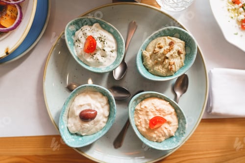 Preview: Delicious sauces and teaspoons on plate in cafe