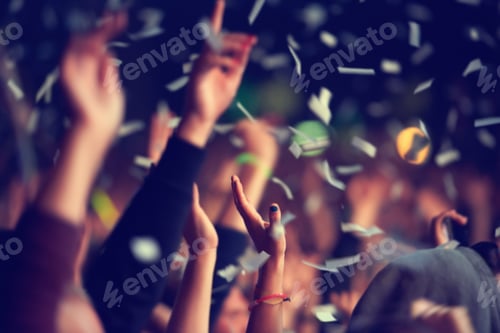 Preview: Wild and free. A music festival audience throwing confetti into the air in celebration.