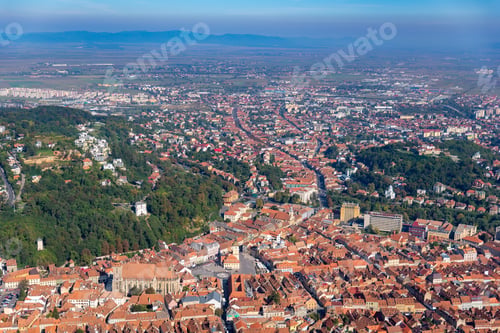 Preview: a large city with lots of brown roofs and trees in the background