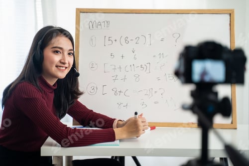 Preview: Asian school woman teacher working from home teaching online math to student studying from home.