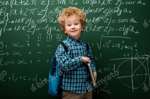 Preview: happy child holding book near chalkboard with mathematical formulas