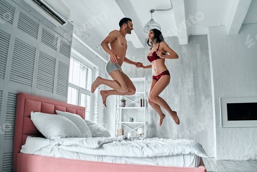 Preview: The happy couple in underwear jumping in the room.
