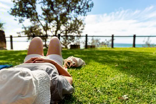Preview: Young Woman Lying on Grass.Woman Taking a Rest on Grass in Noosa National Park,Queensland,Australia
