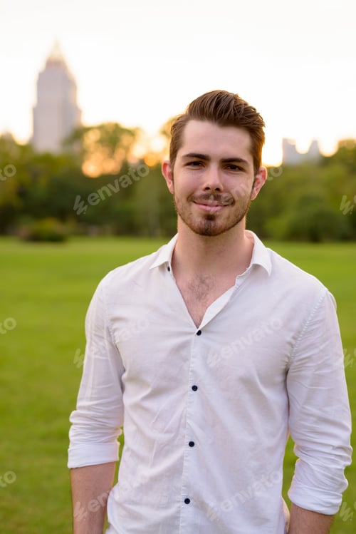 Preview: Portrait of young handsome man smiling in park