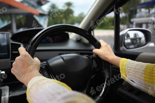 Preview: Senior woman hands steering wheel of a car while driving.