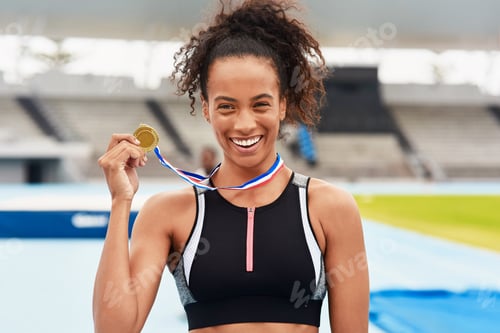 Preview: Cropped portrait of an attractive young female athlete posing with her gold medal out on the track