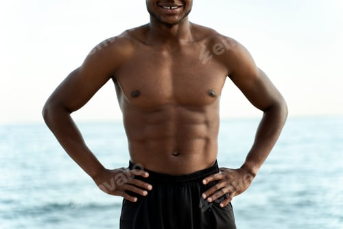 Preview: Man posing with naked torso with summer sea with blue water at the background