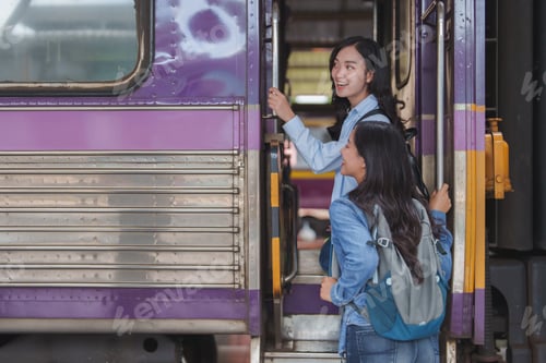 Preview: Two young women boarding train at railway station