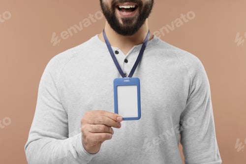 Preview: Man with blank badge on beige background, closeup