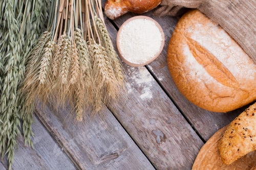 Preview: Flour in wooden bowl and bread assortment.