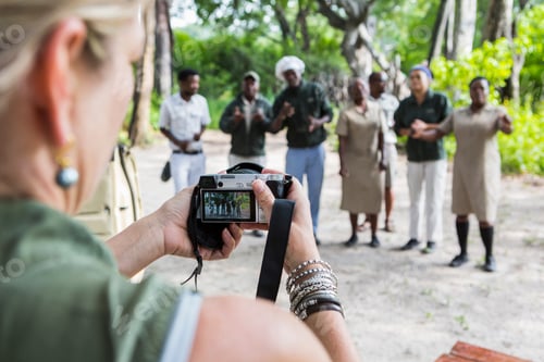 Preview: adult woman taking pictures of tented camp staff, Botswana