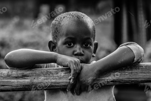 Preview: Black and White of an African boy leaning on a tree