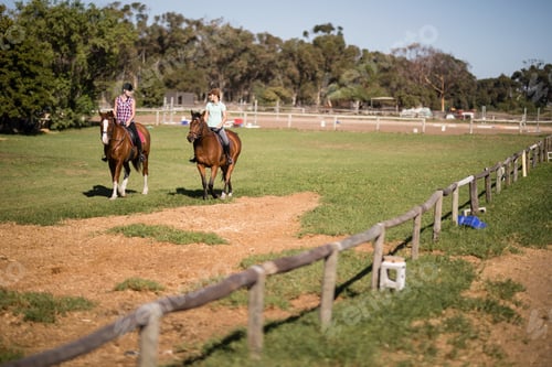Preview: Mid distant view of female friends horseback riding