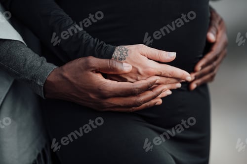 Preview: hands of an interracial couple hug a pregnant tummy.
