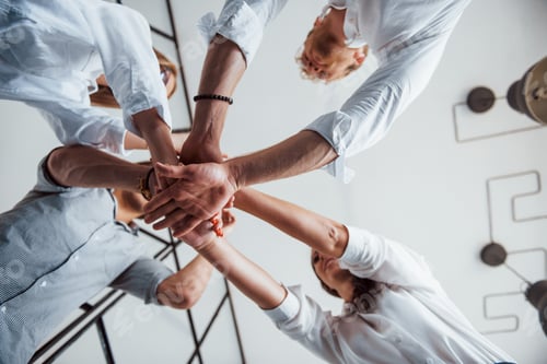 Preview: View from below. Successful business people putting their hands together