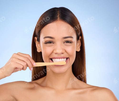 Preview: Portrait, toothbrush and smile with a model woman in studio on a blue background for oral hygiene.