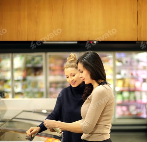 Preview: Two Women Choosing Frozen Food From A Supermarket Freezer