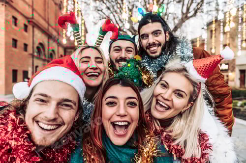Preview: Happy smiling friends taking a selfie, wearing Christmas hats celebrating Christmas night together