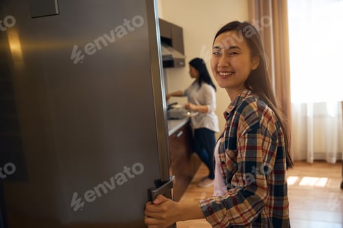 Preview: Daughter and mother in kitchen in morning