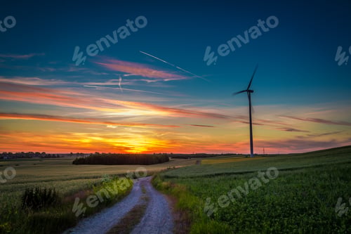 Preview: Stunning colorful dusk over country road and wind turbines, Europe