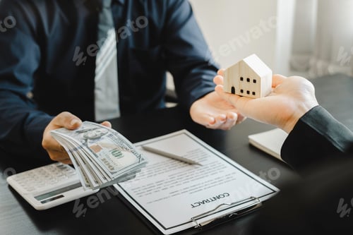 Preview: Real estate agents show miniature house models to the customers and calculate house prices on the ta