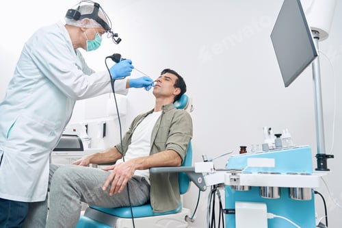 Preview: Doctor examining man with medical instrument at the hospital