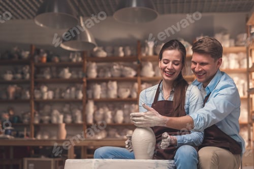 Preview: Smiling couple behind a potter's wheel