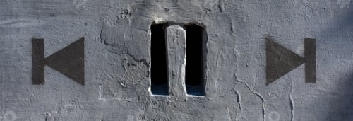 Preview: Back and forth. Drawn on the wall next to two holes on the wall that look like a pause icon.