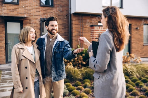 Preview: Happy couple receiving new house keys from real estate agent
