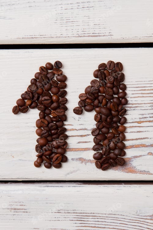 Preview: Brown coffee beans arranged in a shape of eleven.