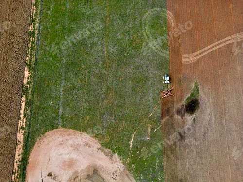 Preview: Aerial shot of a tractor working in the farmland