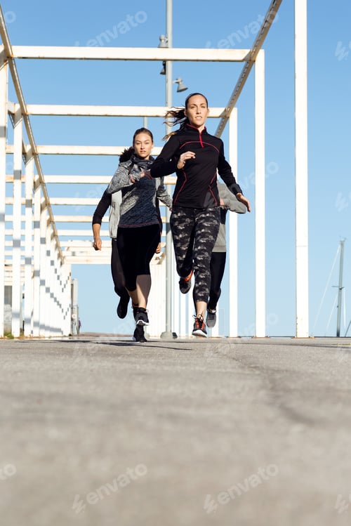 Preview: Portrait of group of friends running in the city.
