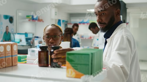 Preview: Man and woman looking at medicaments on shelves