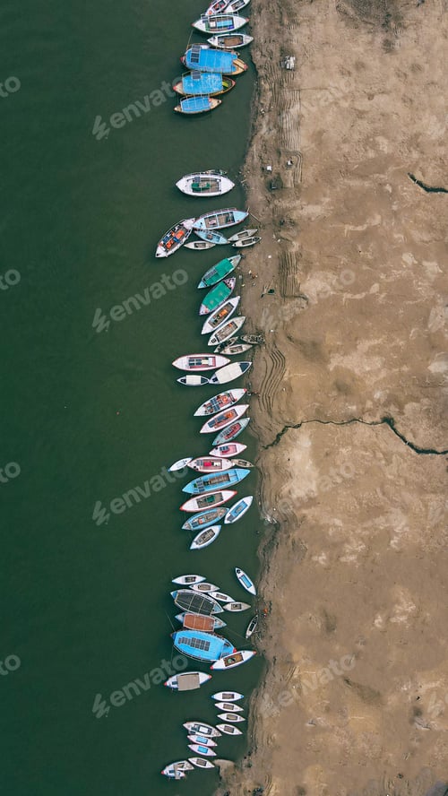 Preview: Aerial shot of colorful boats moored near a sandy beach.