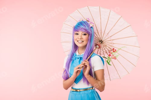 Preview: Smiling asian anime girl in wig holding paper umbrella isolated on pink
