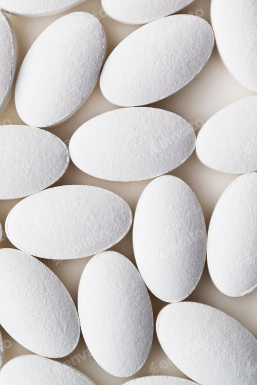 Preview: Pile of white drug pills laying on white background