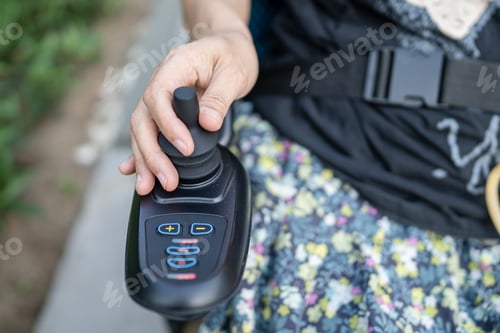Vorschau: Asiatische Patientin im Elektrorollstuhl mit Joystick im Pflegekrankenhaus