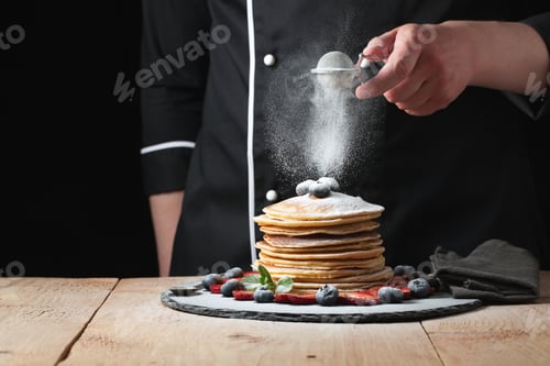 Preview: Serving pancakes with powdered sugar and berries.